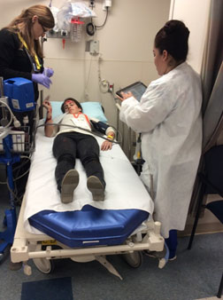 Photo of a simulated patient attended by hospital staff during a disaster drill.